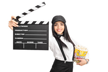 Female movie director holding a clapperboard and popcorn