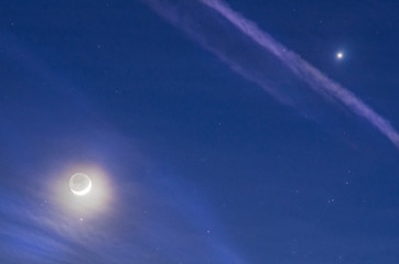 Crescent moon with earth shine, clouds and planet Venus