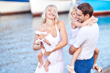 Happy family having fun walking on the mooring near yachts