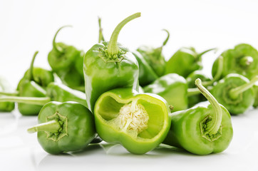 fresh green chilies on white background display