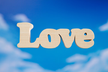 Love wooden letters on sky background