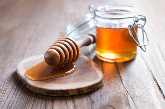 Honey in jur with wooden dipper
