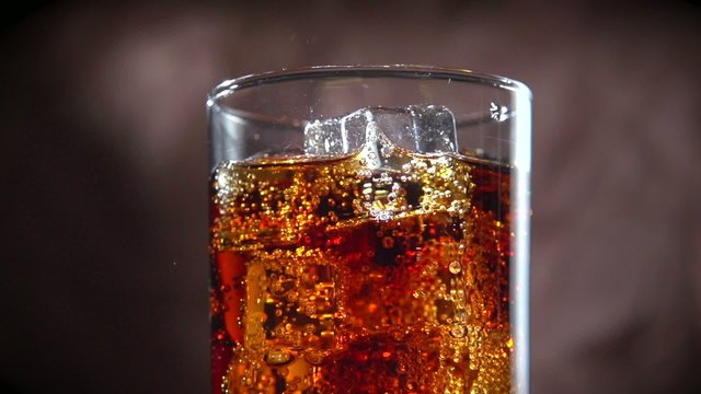 Cola with ice and bubbles in glass. Slow motion. Full HD 1080p
