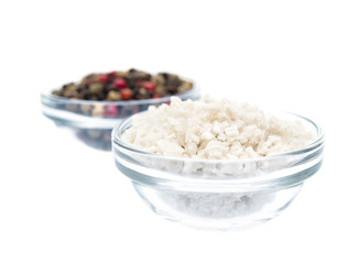 Fototapeta na wymiar Sea salt infront of pepper in glass bowl isolated on white