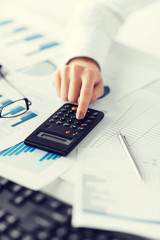 woman hand with calculator and papers