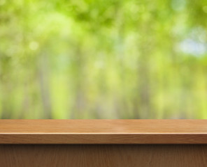empty wood table for product display on green blurred background
