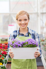 happy woman holding flowers in greenhouse