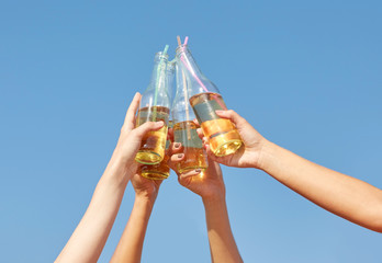 close up of many hands clinking bottles