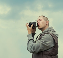 fashionable guy hipster photographer on a cloudy day