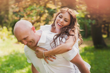 Young beautiful couple running, laughing and having fun in the n