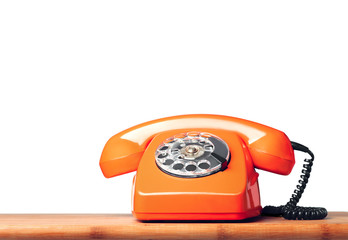 Vintage orange phone on the table Isolated on white