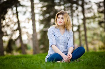 Obraz premium portrait of a beautiful woman sitting in grass