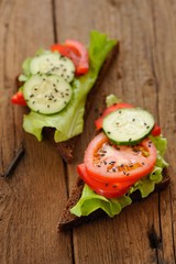 Rye sandwich with salad leaves, tomato, cucumber, bell pepper on