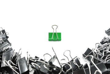 one green paper clip and group of black paper clip