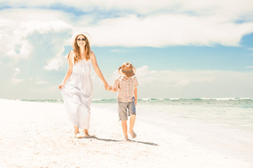 Happy beautiful mother and son enjoying beach time