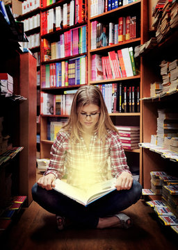 Intelligent female student holding open book with sunshine.