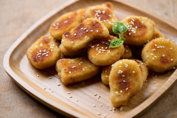Bamboo tray with sesame chicken nuggets, close-up, studio shot