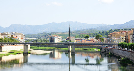 Fototapeta na wymiar Puente de hierro rojo sobre el río Ebro en Tortosa, Tarragona