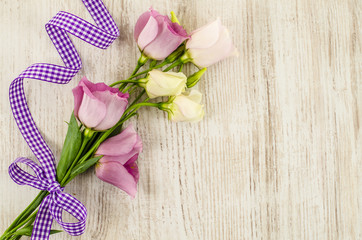 Empty wooden background with colorful flowers and purple ribbon