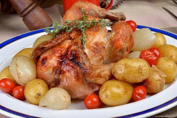 Cockerel baked with potatoes, tomatoes and onions