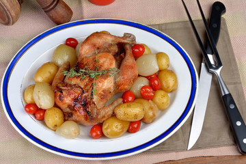 Cockerel baked with potatoes, tomatoes and onions