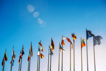 All European Union flags against blue sky in front of parliament