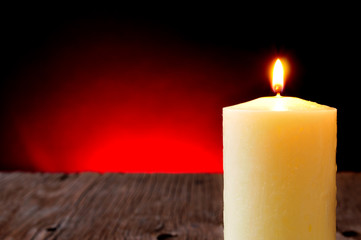 lit candle on a rustic wooden table