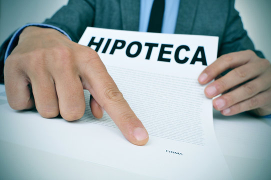 man with a document with the word hipoteca, mortgage loan contra