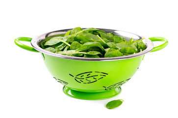 fresh spinach leaves in green colander