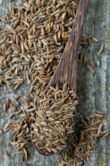 dried cumin on wooden surface