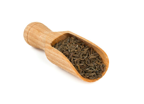dried cumin in a wooden spoon