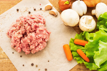 Fresh raw minced meat on wood table, with vegetables