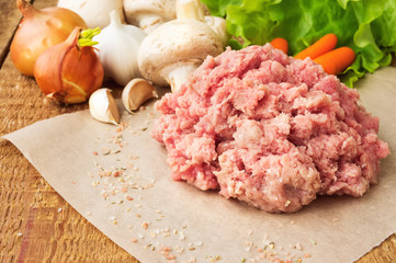 Fresh raw minced meat on wood table, with vegetables