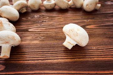 Fresh white champignons on dark wooden table