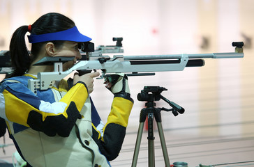woman aiming a pneumatic air rifle - 82015079
