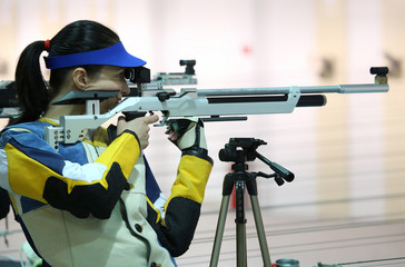 woman aiming a pneumatic air rifle