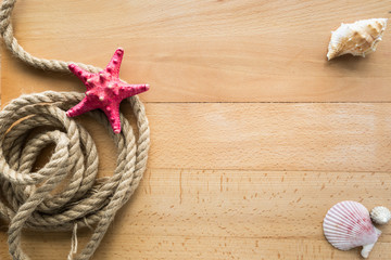 Fototapeta na wymiar View from top on rope, seashells and starfish on wooden boards