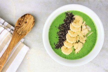 Green smoothie bowl with chia seeds, bananas and almonds