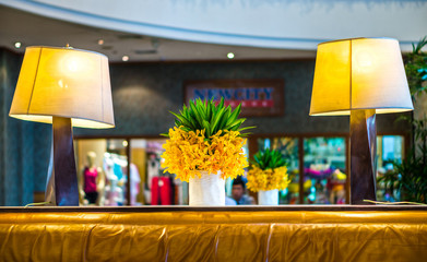 The ornamental flowers in white ceramic vase and electrical lamp