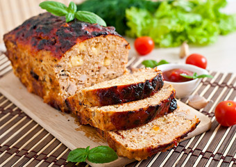 Homemade ground meatloaf with ketchup and basil