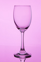 glass with wine on pink background