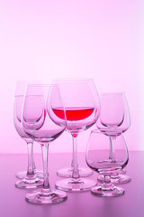 glass with wine on pink background