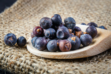 juniper berries on old wooden spoon