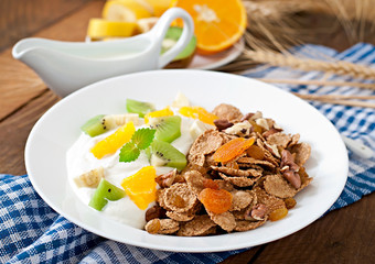 Healthy dessert with muesli and fruit in a white plate on the ta