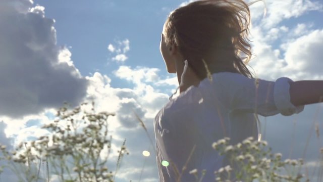 Beautiful young woman over cloudy sky having fun