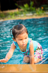 Cute little girl having fun in the swimming pool