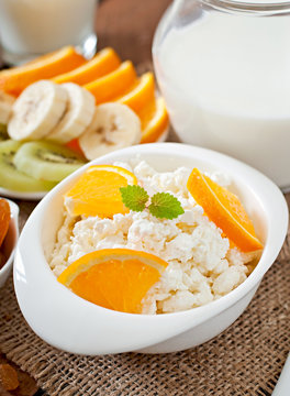 Cottage cheese with orange for breakfast close up
