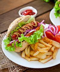 Hot Dogs with French fries on white plate, close-up
