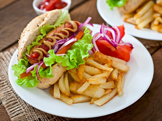 Hot Dogs with French fries on white plate, close-up