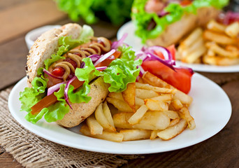 Hot Dogs with French fries on white plate, close-up